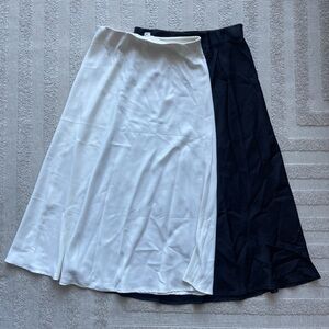 Two faux silk skirts black and white